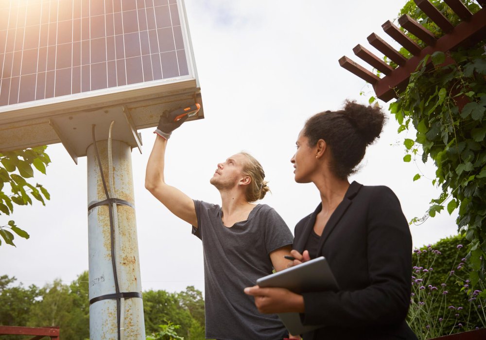 Illustrasjonsfoto. Mann og dame som måler noe på et solcellepanel