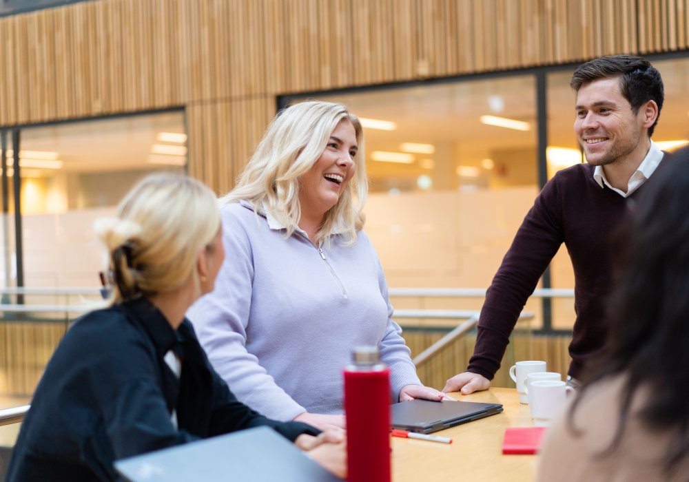 Fornøyde kollegaer som ser på en datamaskin.