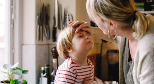 Mor sammen med sykt barn på kjøkkenet.
